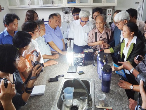 Các nhà khoa học xem công nghệ phát điện bằng nước của TS Nguyễn Chánh Khê và cộng sự - Ảnh: Mai Vọng